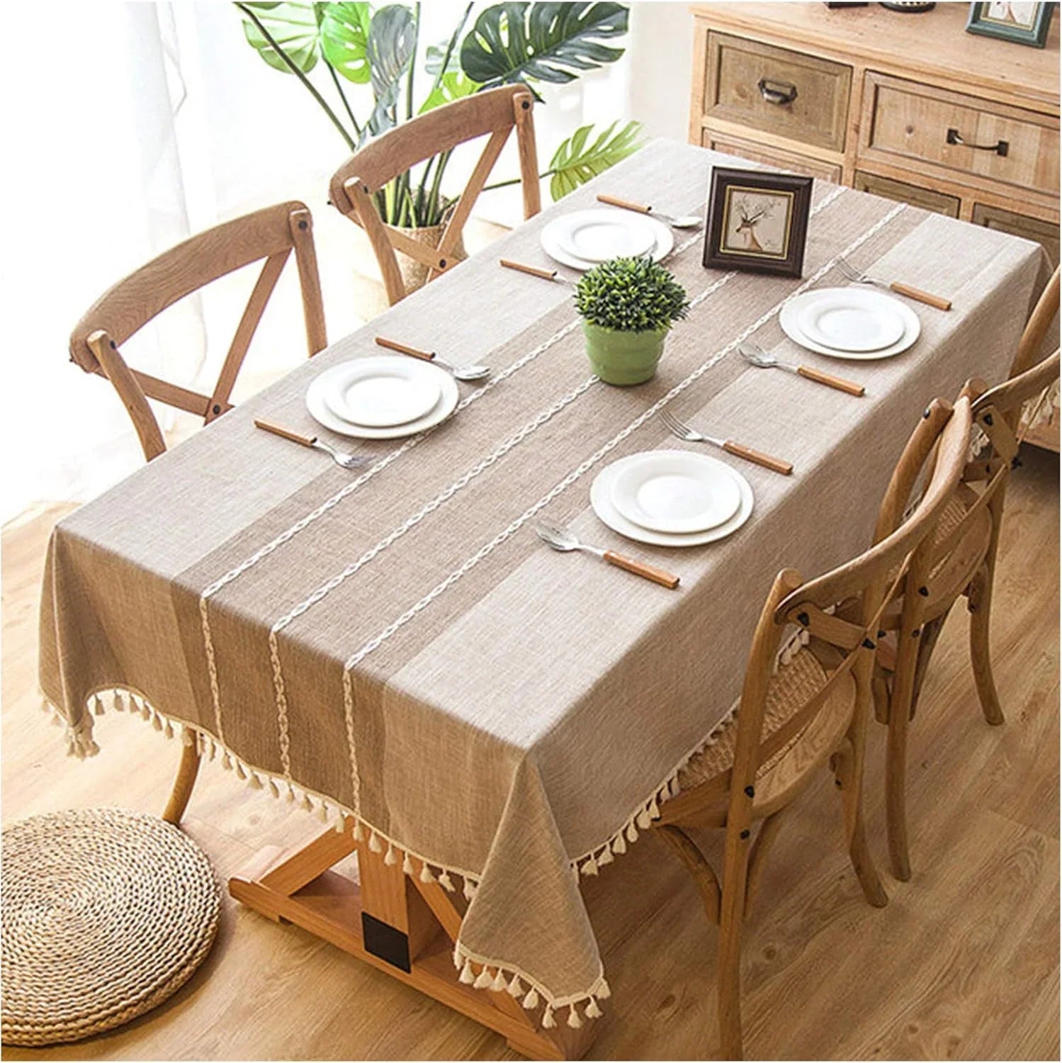 Natural linen table cover with tassels on a wooden dining table